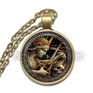 May include: A gold necklace with a round glass pendant depicting a woman wearing a crown, cutting hair with scissors. The pendant has a Greek key border.