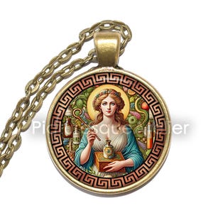 May include: A gold necklace with a round glass pendant featuring a painting of a woman holding a vial and a staff. The woman is surrounded by flowers and plants. The pendant is framed with a gold Greek key design.