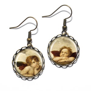 May include: A pair of bronze earrings with a round, scalloped frame. Each earring features a glass cameo of a cherub with wings, set against a cloudy sky background.