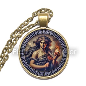 May include: A gold necklace with a round pendant featuring a painting of a woman holding a flaming apple. The pendant is surrounded by a Greek key border.