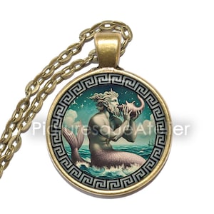 May include: A gold necklace with a round pendant featuring a colorful illustration of a merman blowing a conch shell. The pendant is surrounded by a gold Greek key border.