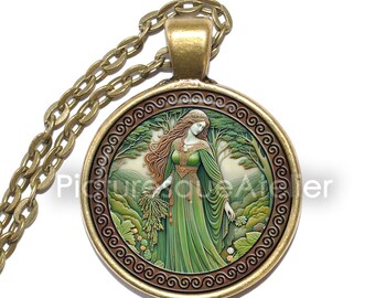 May include: A gold necklace with a round pendant featuring a green-robed woman with long red hair standing in a forest setting. The pendant has a brown and gold border with a Celtic knot design.