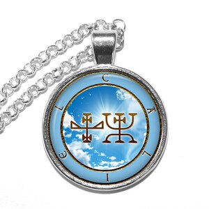 May include: Silver necklace with a round pendant featuring a blue sky with white clouds and a gold sigil. The sigil is surrounded by a circle with the letters "CLAIEL" inscribed around it.