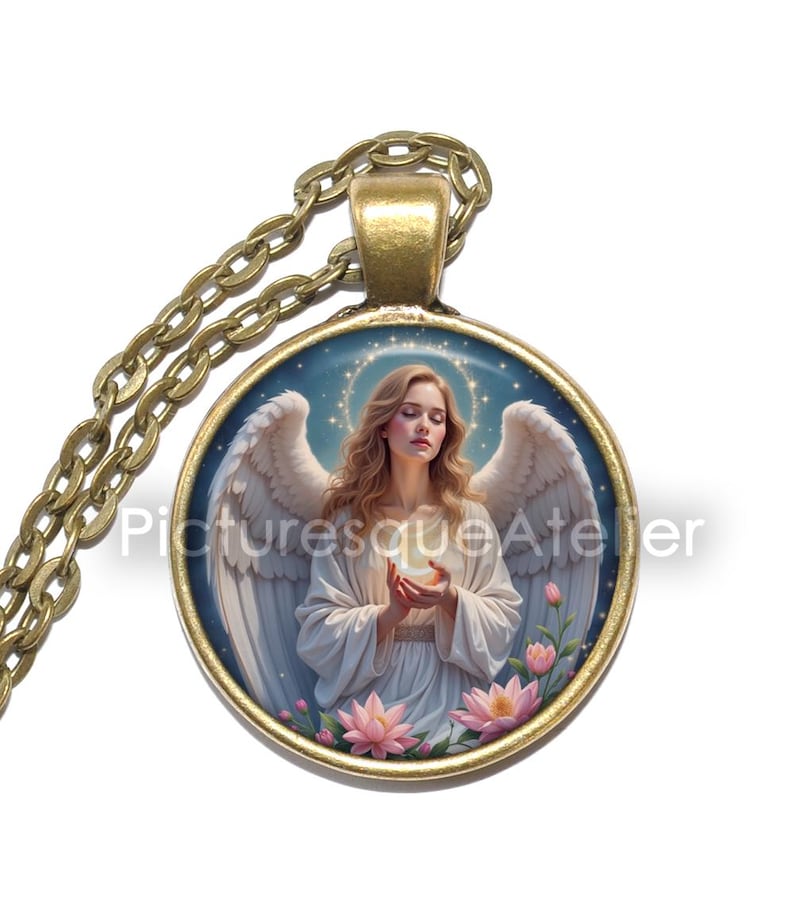 Pu&ograve; includere: Una collana con pendente rotondo con una catena color oro. Il pendente presenta un'illustrazione di un angelo con ali bianche, che tiene in mano un globo luminoso. Fiori rosa sul fondo del pendente. Il testo "Picturesque Atelier" &egrave; sul pendente.