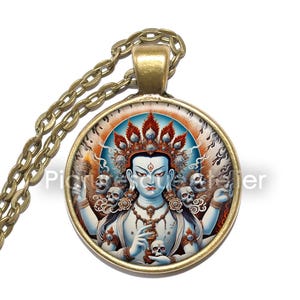May include: A round glass pendant necklace with a bronze chain. The pendant features a colorful image of a deity with multiple arms and skulls, set against a red and orange background.