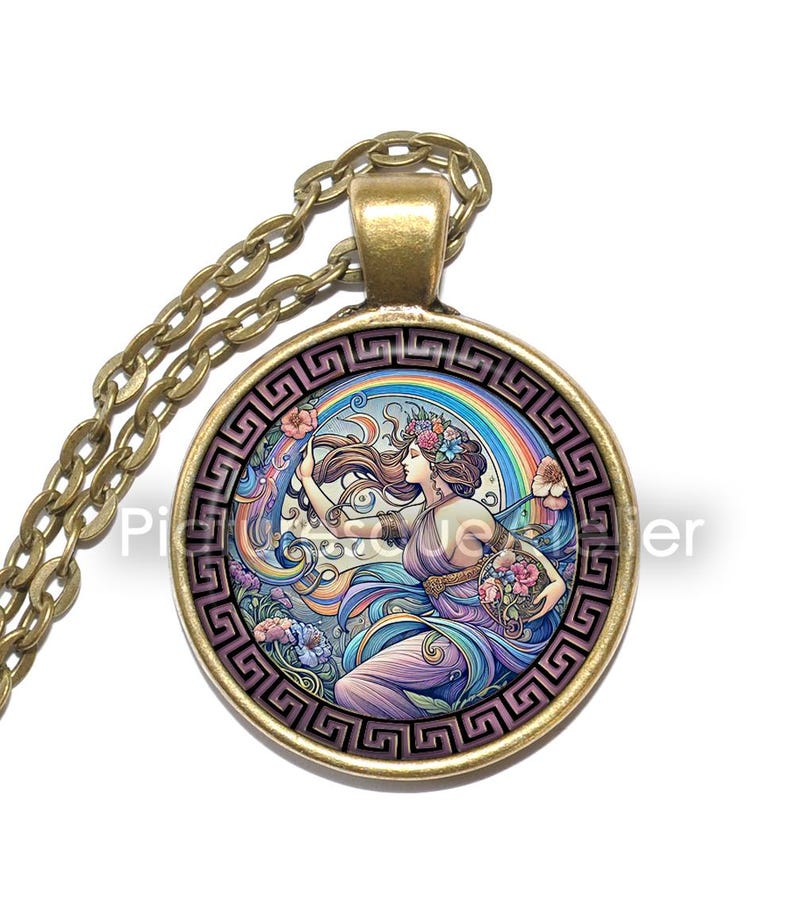 May include: A gold chain necklace with a round pendant featuring a colourful illustration of a woman with flowers in her hair and a rainbow behind her. The pendant is surrounded by a gold Greek key border.