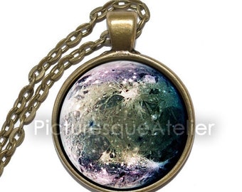 May include: A bronze chain necklace with a round glass pendant featuring a colorful image of a planet with craters and a galaxy background.