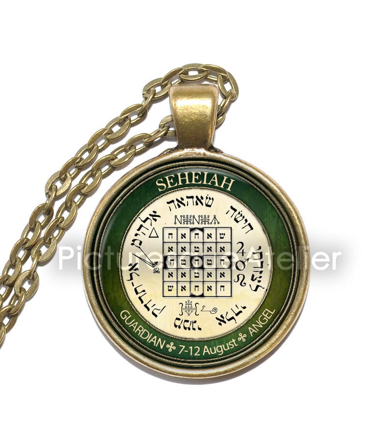 May include: A gold pendant necklace with a green and gold circular charm. The charm features a square grid with Hebrew text and the words "SEHEIAH GUARDIAN 7-12 August ANGEL".
