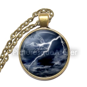 May include: A round pendant necklace with a bronze chain. The pendant features a glass dome with a photograph of a stormy sky with lightning bolts.