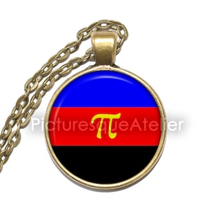 Op de afbeelding: Een ronde hangerketting met een goudkleurige ketting. De hanger heeft een blauw, rood en zwart ontwerp met een geel symbool. De tekst "Picturesque Atelier" is zichtbaar op de hanger.