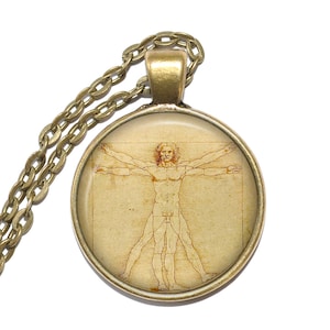Może przedstawiać: Bransoletka z brązu z okrągłym szklanym wisiorkiem przedstawiającym vintage'owy rysunek Człowieka Witruwiańskiego, słynnego anatomicznego studium Leonarda da Vinci.