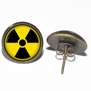 May include: A pair of bronze stud earrings with a yellow and black radiation symbol on the front.