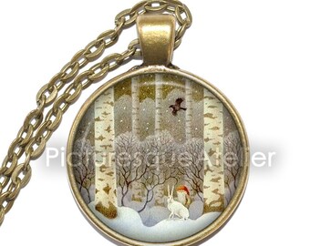May include: A round glass pendant necklace with a winter scene. The pendant features a snowy forest with birch trees, a white rabbit, and a flying bird. The necklace is made of a bronze chain.