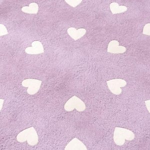 May include: A soft, textured lavender fabric featuring a repeating pattern of white heart shapes arranged in a grid. The material has a plush, fuzzy surface texture throughout, with the white hearts contrasting against the light purple background.