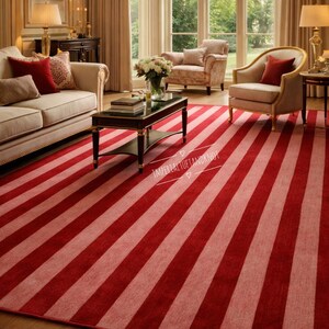 Peut inclure: Un tapis à rayures rouges et rose clair dans un salon. Les rayures diagonales du tapis attirent l'attention. La pièce comprend un canapé, des fauteuils, une table basse et de grandes fenêtres.