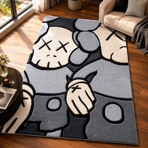 Puede incluir: Una alfombra rectangular que presenta un patr&oacute;n gr&aacute;fico repetitivo de personajes de dibujos animados estilizados con ojos en forma de X. El dise&ntilde;o utiliza una paleta de colores monocrom&aacute;tica de negro, gris oscuro, gris claro y blanco roto.