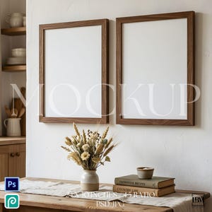 May include: Two wooden framed blank art prints, each 24 x 30 inches, are mounted on a white wall. A vase of dried flowers sits on a wooden table, along with two books and a small bowl. The word "MOCKUP" is printed on the image.