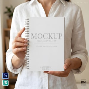 以下が含まれることがあります： 表紙にMOCKUP PSD SMART OBJECT LITTLE BASH MOCKUPSおよび15.24 X 20.32 CM PSD JPGという文字が印刷された白いスパイラル綴じのノート。ノートは無地の白いシャツを背景に垂直に保持されています。