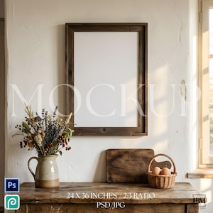 Può includere: Una cornice in legno con interno bianco è appesa a una parete bianca strutturata. Un bouquet di fiori secchi è posto in una brocca di ceramica su un tavolo di legno. Un piccolo cestino con uova e un tagliere in legno sono anche sul tavolo. La cornice misura 61 x 91 cm.