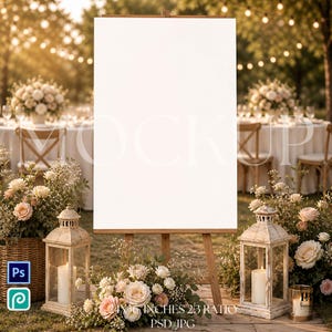 May include: A blank white sign on a wooden easel, set outdoors for a wedding or event. The scene includes floral arrangements, lanterns, and tables with chairs. The sign is 24 x 36 inches with a 2:3 ratio.