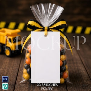 May include: A clear cellophane bag filled with orange, yellow, and black candies, tied with a black and yellow ribbon. A blank white tag hangs from the ribbon. The text "2 x 3.5 inches PSD JPG" is at the bottom.