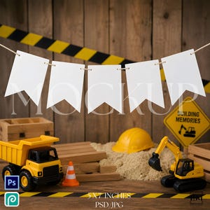 May include: A construction-themed mockup with a banner of white flags, toy construction vehicles, a yellow hard hat, and a road sign that says "Building Memories". The scene includes sand, wooden blocks, and a safety cone.