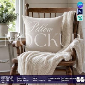 May include: A square off-white throw pillow placed on a wooden chair, draped with a cream-colored knitted throw blanket featuring fringe edges. The pillow surface displays the semi-transparent white text Pillow MOCKUP in a cursive and serif font.
