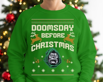 以下が含まれることがあります： DOOMSDAY BEFORE CHRISTMASという白いブロック体の文字がプリントされた、鮮やかなグリーンのクルーネックトレーナー。デザインには、2頭の淡い茶色のトナカイ、小さな赤いヒイラギの実、そして緑の背景に白い雪の結晶が描かれています。