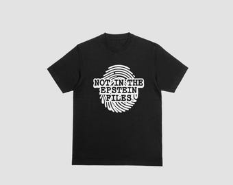 以下が含まれることがあります： 白い指紋のデザインが施された黒いTシャツ。「NOT IN THE EPSTEIN FILES」のテキストが指紋の中に配置されています。クルーネックと半袖で、カジュアルな服装に適しています。