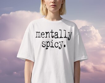 以下が含まれることがあります： 黒い「mentally spicy」の文字がプリントされた白いTシャツ。Tシャツは半袖でゆったりとしたフィット感。背景は柔らかい雲の多い空です。