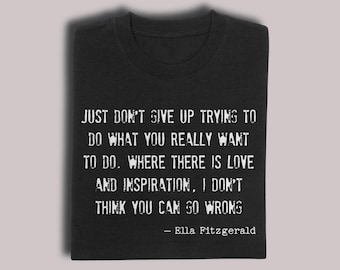 以下が含まれることがあります： 黒いTシャツ。エラ・フィッツジェラルドの引用句が白いかすれたフォントで書かれています。引用句は「JUST DON'T GIVE UP TRYING TO DO WHAT YOU REALLY WANT TO DO. WHERE THERE IS LOVE AND INSPIRATION, I DON'T THINK YOU CAN GO WRONG.」です。