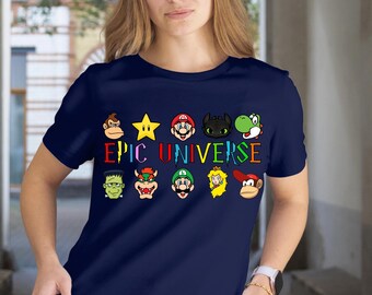 以下が含まれることがあります： 鮮やかな「EPIC UNIVERSE」のデザインと漫画のキャラクターが特徴のネイビーブルーのTシャツ。デザインには星、猿、その他のキャラクターが含まれています。シャツは柔らかい素材で作られています。