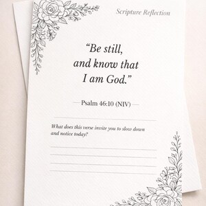 May include: White card with floral corner designs and the text "Scripture Reflection." The card features the quote "Be still, and know that I am God." from Psalm 46:10 (NIV), with space for reflection.
