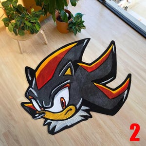 Op de afbeelding: Een zwart, rood, geel en wit tapijt in de vorm van het personage Shadow the Hedgehog. Het tapijt ligt op een lichte houten vloer. Het nummer 2 is rechtsonder zichtbaar.