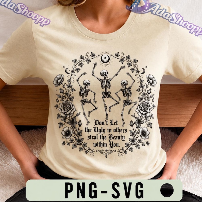 May include: A cream-colored t-shirt featuring a black graphic of three dancing skeletons surrounded by a floral wreath of roses and vines. The text reads, "Don't Let the Ugly in others steal the Beauty within You." A crescent moon sits at the top.