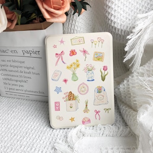 May include: A cream-colored phone case adorned with whimsical illustrations of flowers, bows, and a smiling bag. The case features a rectangular shape and is decorated with various pastel-colored drawings.