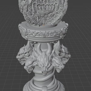 Peut inclure: Une sculpture grise détaillée représentant une grande sphère texturée sur un piédestal. Le piédestal est orné de sculptures complexes, notamment de multiples têtes de dragons et de volutes ornées, créant un thème fantastique.