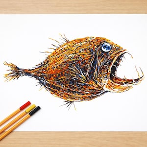 Puede incluir: Ilustración de un pez con la boca abierta, en tonos naranja, marrón y azul. El dibujo está realizado sobre papel blanco, con tres bolígrafos de colores rojo, amarillo y negro. El conjunto está sobre una superficie de madera.