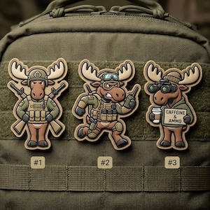 May include: Three cartoon moose patches with military-themed designs. The moose are wearing tactical gear and holding weapons or communication devices. One patch reads "Caffeine & Ammo". The patches are tan, brown, green, and black.