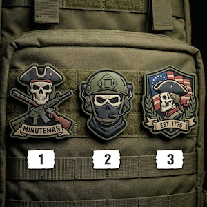 May include: Three tactical patches with military-themed designs. One patch features a skull wearing a tricorn hat and holding a rifle, labeled "MINUTEMAN." Another depicts a masked figure in a helmet. The third shows a skull with a tricorn hat, the American flag, and the text "EST. 1776."