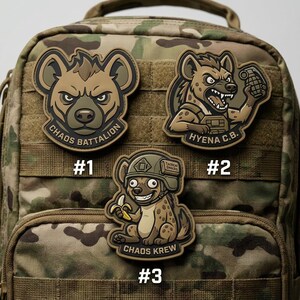 May include: Three tactical patches with hyena designs. One patch reads "Chaos Battalion", another "Hyena C.B.", and the third "Chaos Krew". The patches are in shades of brown, tan, and green, with black and white accents. The patches are attached to a camouflage backpack.