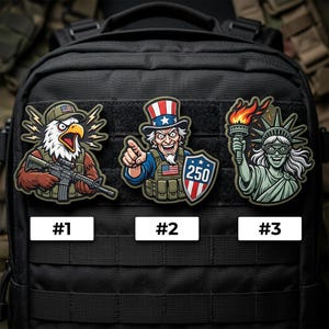 May include: Three embroidered patches featuring patriotic American designs. One patch depicts an eagle holding a rifle, another shows Uncle Sam, and the third features the Statue of Liberty. Each patch has a white label with a number.