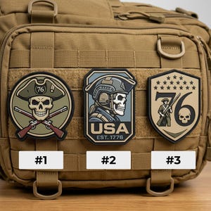 May include: Three embroidered patches with patriotic themes are displayed on a tan tactical bag. The patches feature skull designs, the number 76, and the text "USA EST. 1776". Each patch has a unique design and color scheme.