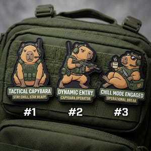May include: Three embroidered patches featuring capybaras in tactical gear. The patches read "Tactical Capybara," "Dynamic Entry," and "Chill Mode Engaged." Each capybara is depicted with military equipment, and the patches are set against a green background.