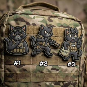 May include: Three tactical cat patches with military-style gear. The cats are gray with angry expressions. One is shushing, another holding a rifle, and the third with a bag of catnip and a radio. Each patch is numbered.