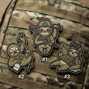 May include: Three cartoon sloth patches in military gear. One sloth holds a rifle, another hangs from a branch with a can, and the third is sleeping. Each patch is numbered and set against a camouflage background.