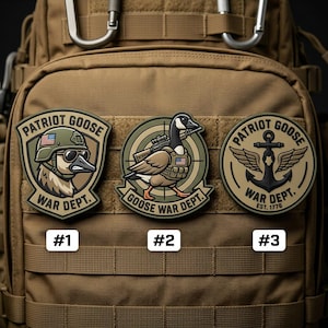 May include: Three embroidered patches with the text "PATRIOT GOOSE" and "WAR DEPT." are displayed on a tan backpack. The patches feature a goose in military attire, with an American flag. One patch has an anchor and wings.
