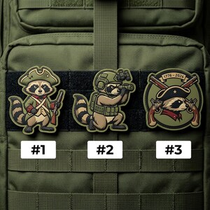 May include: Three cartoon raccoon patches with military themes. One raccoon wears a colonial hat and holds a rifle. Another raccoon uses binoculars, and the third patch features crossed pistols and the years 1776-2026.