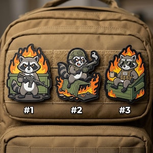 May include: Three embroidered patches featuring cartoon raccoons in various scenarios. One raccoon stands in a dumpster holding a rifle, another sits on a dumpster with a rifle, and the third sits in a dumpster wearing sunglasses and holding a coffee cup. Each patch is surrounded by flames.
