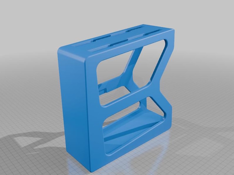 May include: A bright blue, rectangular, open-frame storage organizer featuring a solid top surface with two elongated slots and a hollow interior structure with a single horizontal support bar, designed with a geometric, angular side profile.
